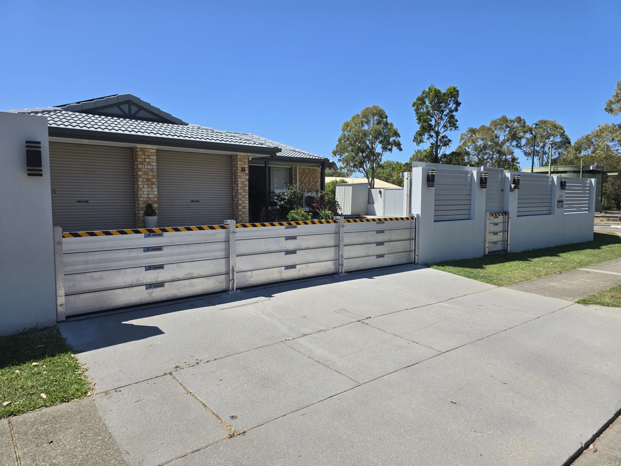 demountable flood barriers installed across residential property in Bald Hills QLD to prevent water entering during creek flooding